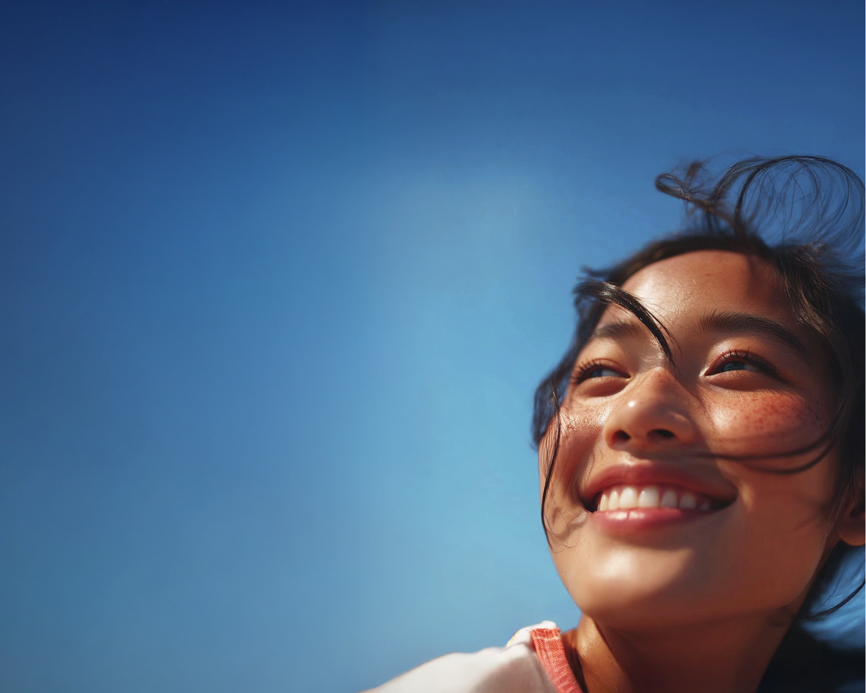 Woman smiling with a clear blue sky background